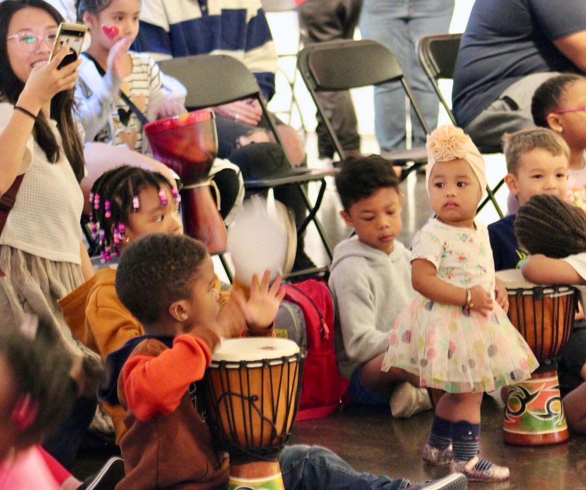 Children at a drum circle community event at Barbara Bush Library