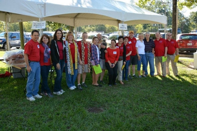 Large group of Cypress Creek Cultural District volunteers and board members posing under a tent at CreekFest Houston
