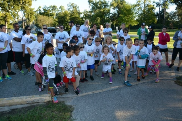 Large group of children and adults in CreekFest t-shirts lined up at the start of the Color the Creek race