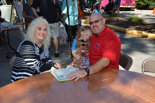 Family signing in at a table at CreekFest Houston