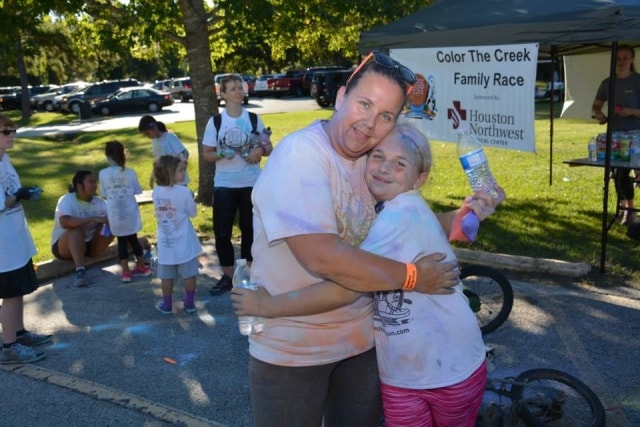 Father and daughter hugging after Color the Creek Family Race