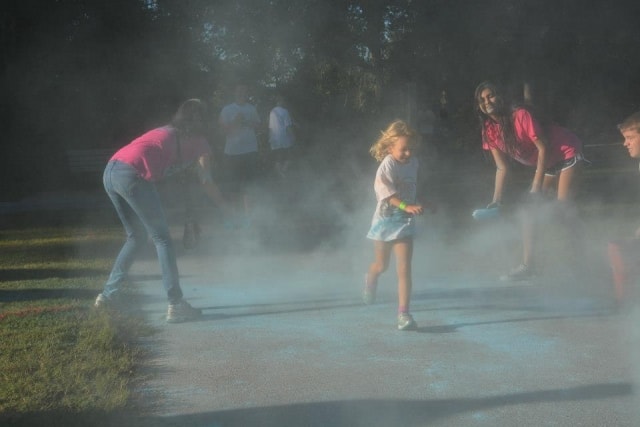 Children playing in color powder mist at CreekFest