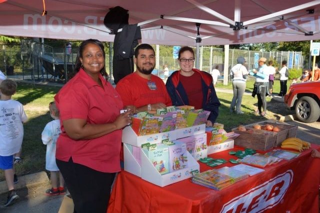 H-E-B volunteers with books and produce at CreekFest Houston