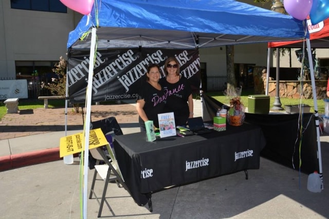 Jazzercise booth with two volunteers at CreekFest Houston