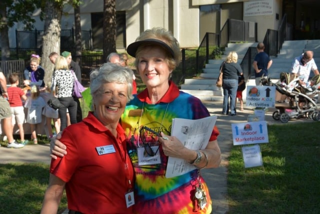 Two female volunteers smiling outside at CreekFest Houston