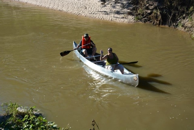Two people paddling a canoe on Cypress Creek at CreekFest