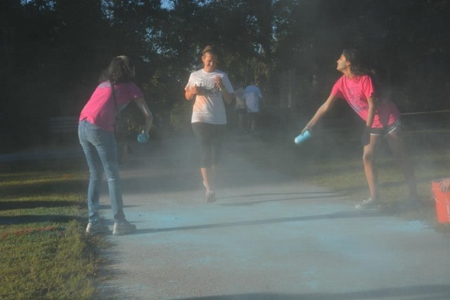 Participants throwing color powder at CreekFest run