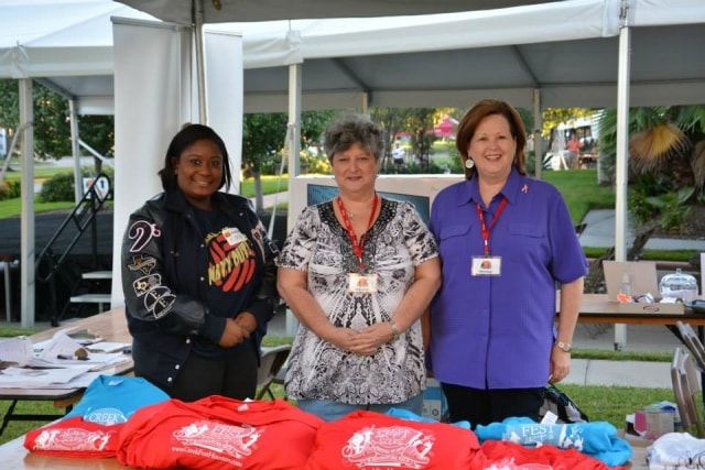 Three volunteers with CreekFest t-shirts at an outdoor booth