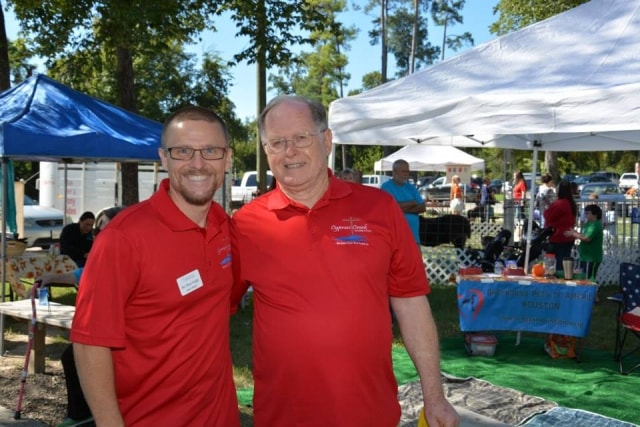 Two men in red Cypress Creek polo shirts at CreekFest Houston