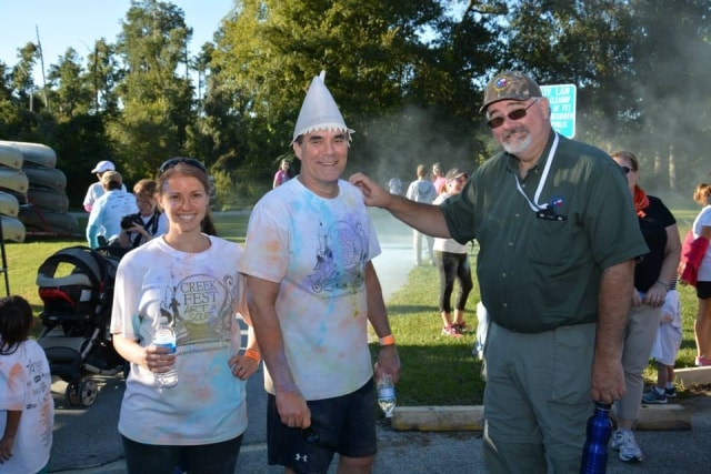 Three color run participants in tie-dye shirts after the Color the Creek race