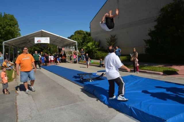 Gymnast performing a backflip on a trampoline at CreekFest Houston
