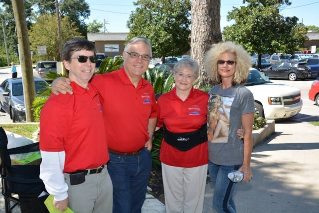 Four Cypress Creek Cultural District volunteers in red polo shirts at CreekFest