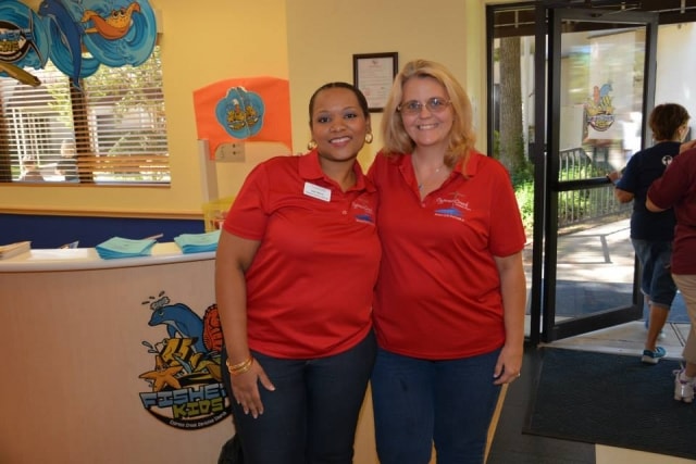 Two staff members at CreekFest Houston welcome desk