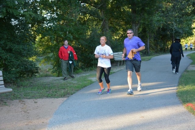 Two runners jogging together on the Cypress Creek trail during the Color the Creek race