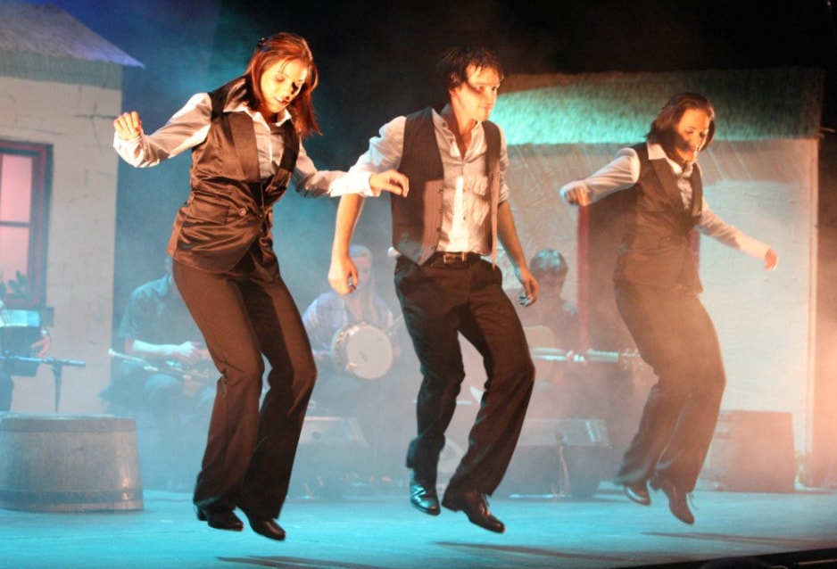 FACE Irish dancers performing on stage with aqua blue lighting