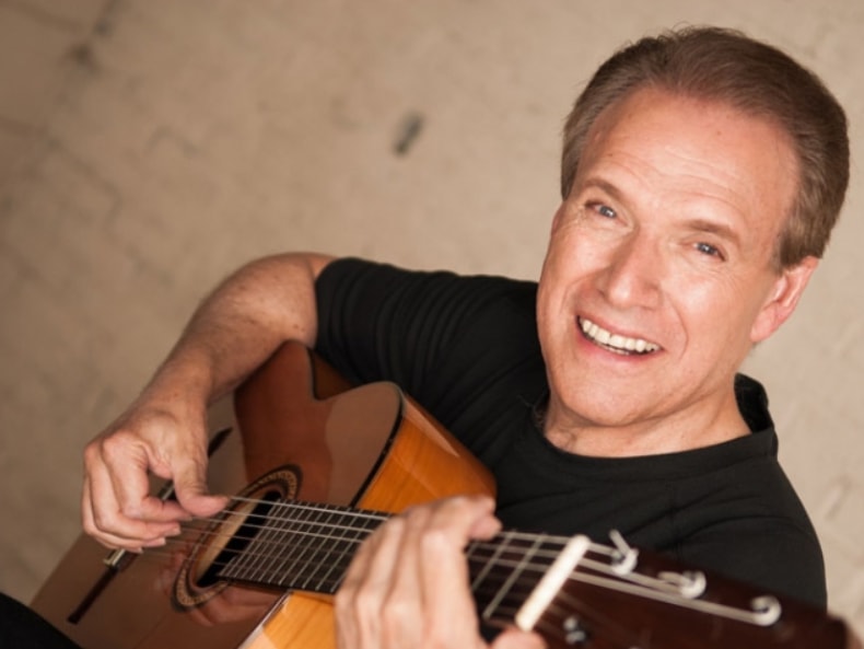 Guitarist portrait smiling with acoustic guitar