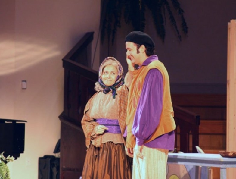 Children's theater performers in period costume on stage
