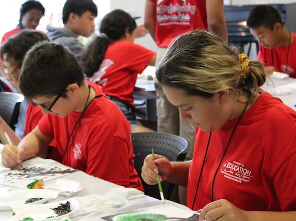 Pearl Art Classes — adult, teen, and child with round circle of rocks