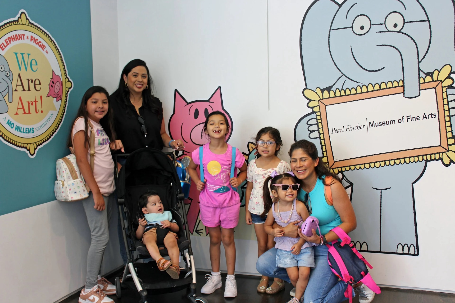 Families posing in front of the Elephant and Piggie We Are Art exhibit at Pearl Fincher Museum