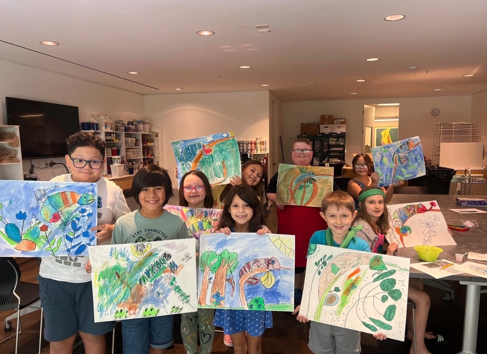 Children with docent viewing display case exhibit at Pearl Fincher Museum